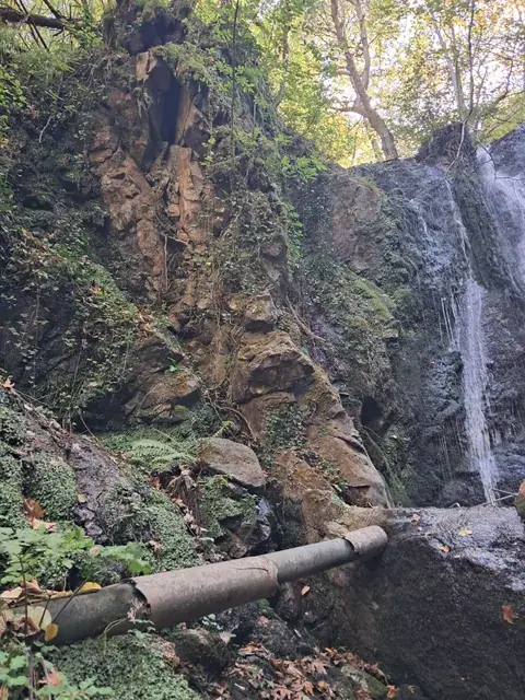 Водоводната цева под карпестата падина кај водопадот